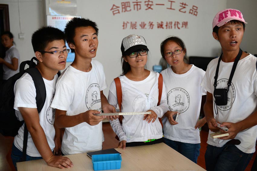 Xu Zede (L2) enquires job information at an arts production company on July 18. (Xinhua/ Zhang Rui) 