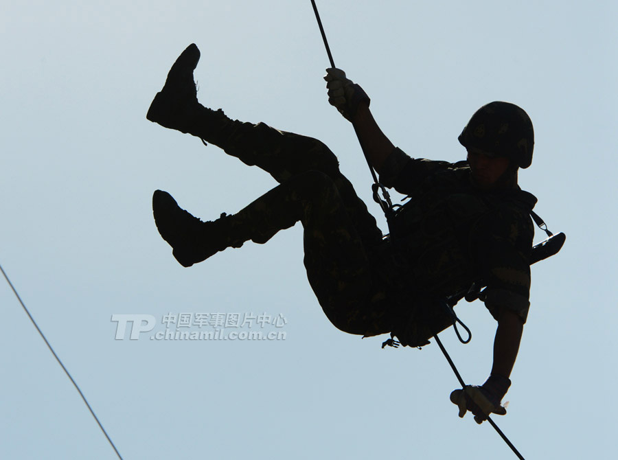 The special operation members use a rope to climb a 12-meter-high building, and then slide down from the building on the another side. (China Military Online/Li Jing)
