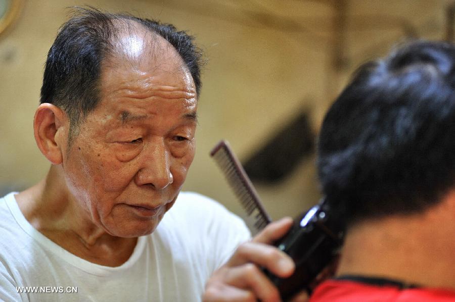 Ou Shubin serves a customer at his old-fashioned barbershop at No. 76, Meihua Road in Ningxiang County, central China's Hunan Province, July 21, 2013. Affectionately known as Ou Die, or Daddy Ou in the neighborhood, the 78-year-old barber has been in the business for 66 years and run the current shop for 33 years, offering traditional services to old customers. (Xinhua/Long Hongtao) 
