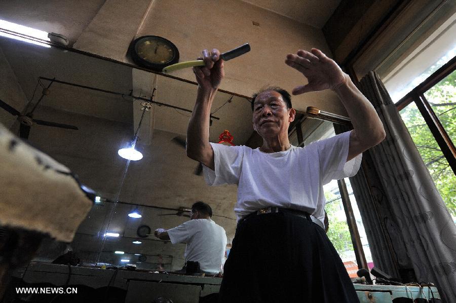 Ou Shubin exercises his wrists at his old-fashioned barbershop at No. 76, Meihua Road in Ningxiang County, central China's Hunan Province, July 21, 2013. Affectionately known as Ou Die, or Daddy Ou in the neighborhood, the 78-year-old barber has been in the business for 66 years and run the current shop for 33 years, offering traditional services to old customers. (Xinhua/Long Hongtao) 