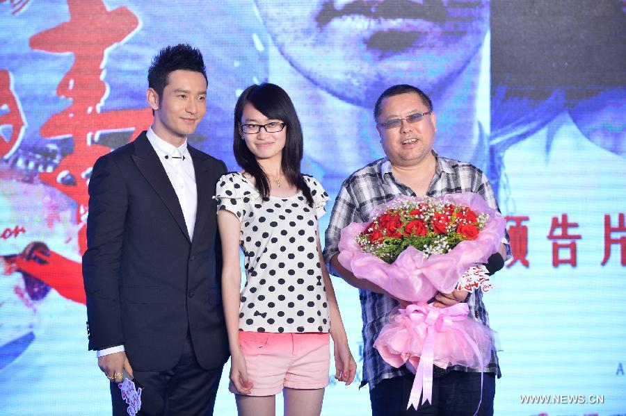Actor Huang Xiaoming (L), director Gao Qunshu (R) and a movie fan pose for photos during the trailer release conference of the movie "Crimes of Passion" in Beijing, capital of China, July 22, 2013. The movie "Crimes of Passion" directed by Gao Qunshu will hit the screen on Aug. 9. (Xinhua/Zhao Dingzhe)