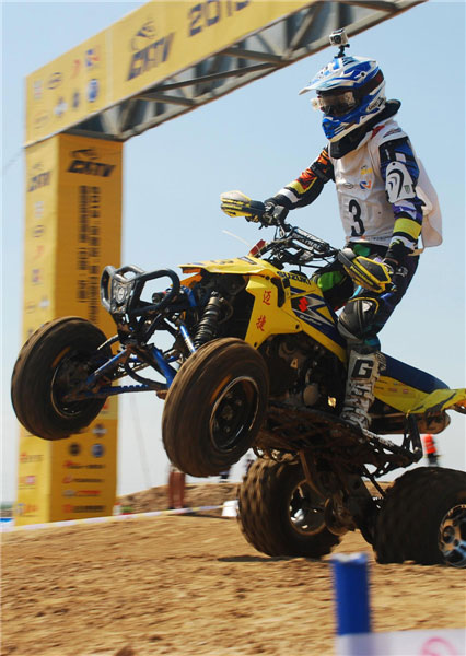 An all-terrain vehicle rider races during the China ATVs and International Invitational Tournament on July 21, 2013 in Dongying city, Shandong province.(Source:China Daily/ Photo:Xinhua)　