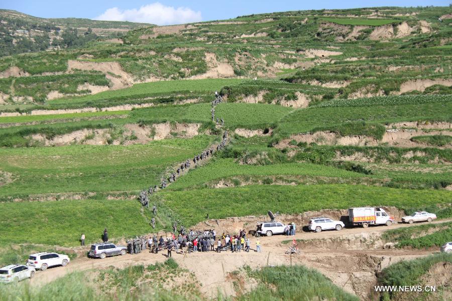 Rescuers walk on a mountain road to reach the hard-hit Yongxing Village of Minxian County, northwest China's Gansu Province, July 22, 2013. The death toll has climbed to 89 in the 6.6-magnitude earthquake which jolted a juncture region of Minxian County and Zhangxian County in Dingxi City Monday morning. (Xinhua/Fan Yongqiang)