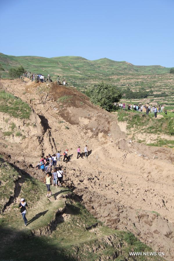 Rescuers walk on a mountain road to reach the hard-hit Yongguang Village of Minxian County, northwest China's Gansu Province, July 22, 2013. The death toll has climbed to 89 in the 6.6-magnitude earthquake which jolted a juncture region of Minxian County and Zhangxian County in Dingxi City Monday morning. (Xinhua/Fan Yongqiang)
