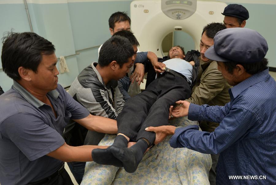 An injured man receives CT examination at a hospital in Minxian County, northwest China's Gansu Province, July 22, 2013. The death toll has climbed to 89 in the 6.6-magnitude earthquake which jolted a juncture region of Minxian County and Zhangxian County in Dingxi City Monday morning. (Xinhua/Liu Xiao) 