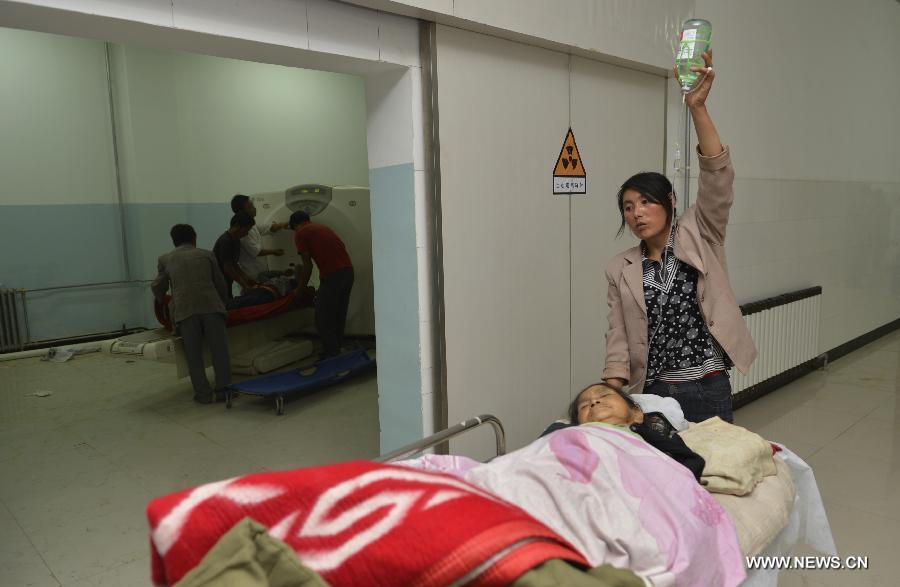 An injured receives medical checkup while another waits at a hospital in Minxian County, northwest China's Gansu Province, July 22, 2013. The death toll has climbed to 89 in the 6.6-magnitude earthquake which jolted a juncture region of Minxian County and Zhangxian County in Dingxi City Monday morning. (Xinhua/Liu Xiao) 