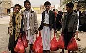 People to receive free food from charity in Sanaa