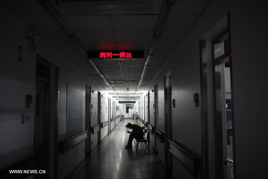A guard sits outside a ward where lies a person injured in a knife attack, at the Xuanwu Hospital in Beijing, China, July 22, 2013. A knife-wielding man injured four people on Monday in a Carrefour store in Beijing, police confirmed. The suspect, a Beijing local surnamed Wang, was captured on the spot, police said. The injured have been taken to hospital. (Xinhua/Jin Liwang)