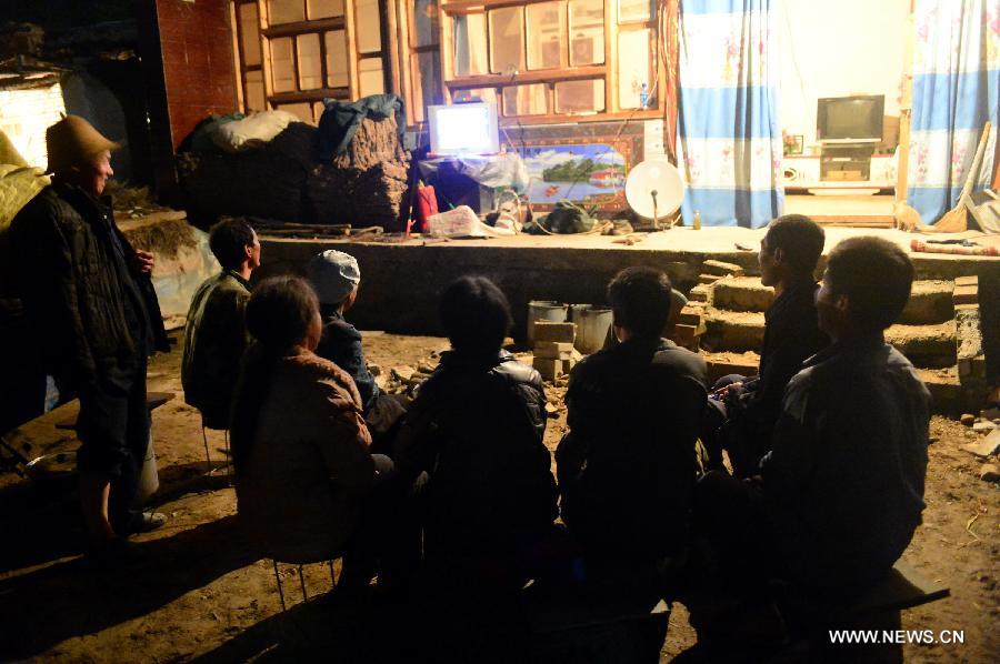 Villages watch TV to learn the earthquake news at quake-hit Hadiha Village of Minxian County, northwest China's Gansu Province, July 22, 2013. The death toll has climbed to 89 in the 6.6-magnitude earthquake which jolted a juncture region of Minxian County and Zhangxian County in Dingxi City Monday morning. (Xinhua/Zhang Meng)