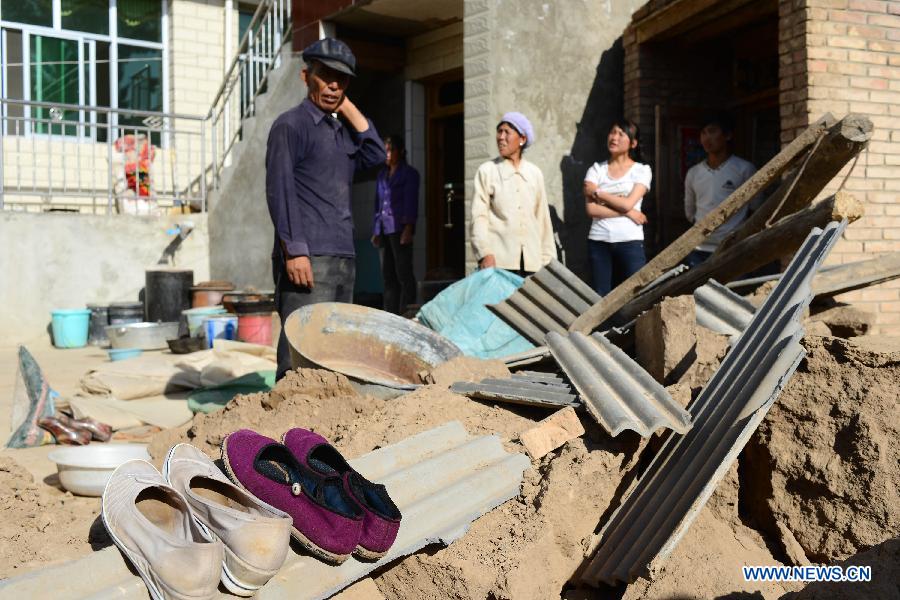 Villagers view a collapsed house in Majiagou Village, Meichuan Town, Minxian County, northwest China's Gansu Province, July 22, 2013. A 6.6-magnitude quake jolted the border of Minxian and Zhangxian counties in Gansu at 7:45 a.m. on Monday. (Xinhua/Jin Liangkuai)