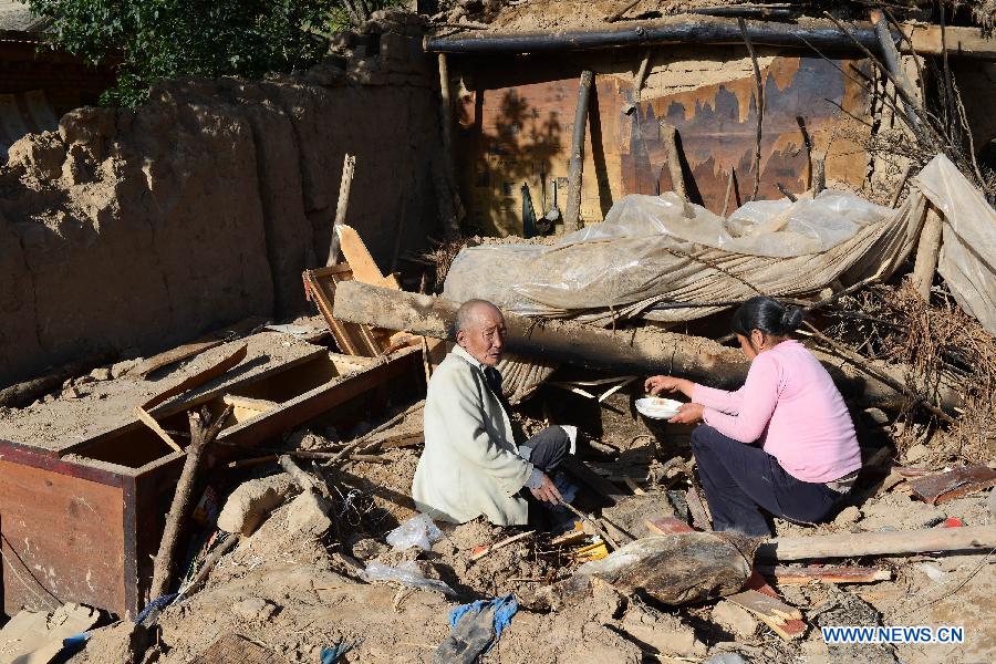 Villagers salvage their belongings on the ruins of a house damaged in a quake in Majiagou Village, Meichuan Town, Minxian County, northwest China's Gansu Province, July 22, 2013. A 6.6-magnitude quake jolted the border of Minxian and Zhangxian counties in Gansu at 7:45 a.m. on Monday. (Xinhua/Jin Liangkuai)
