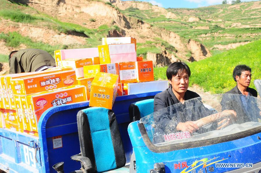 Villagers transport relief goods after a 6.6-magnitude quake jolted Yongguang Village, Meichuan Town, Minxian County, northwest China's Gansu Province, July 22, 2013. At least nine villagers in Yongguang were killed in the quake and 12 others were burried in a landslide triggered by the quake. The rescue work is underway. (Xinhua/Tu Guoxi)