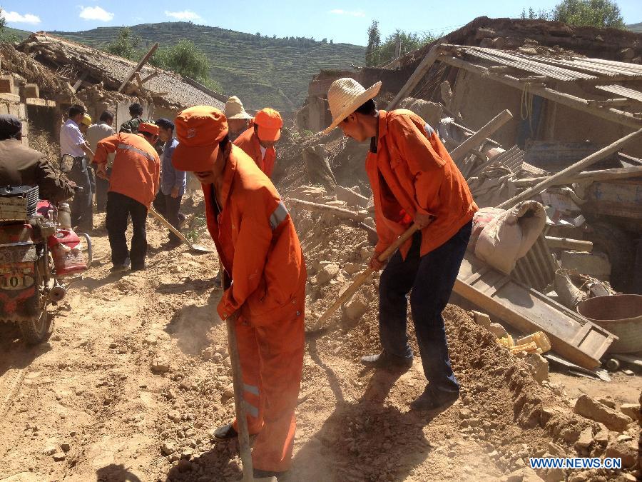 Workers repair a damaged road in Minxian County, northwest China's Gansu Province, after a 6.6-magnitude earthquake jolted the province, on July 22, 2013. (Xinhua/Hou Zhiliang)