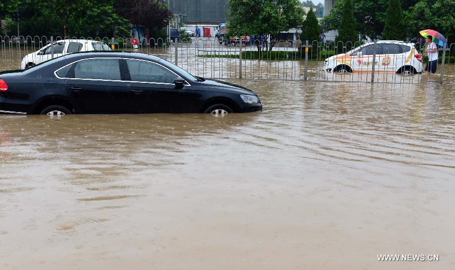 Cars are trapped on the waterlogged Lianhua Road in Jinan, capital of east China's Shandong Province, July 23, 2013. A heavy rainfall hit Jinan on Tuesday. (Xinhua/Guo Xulei)