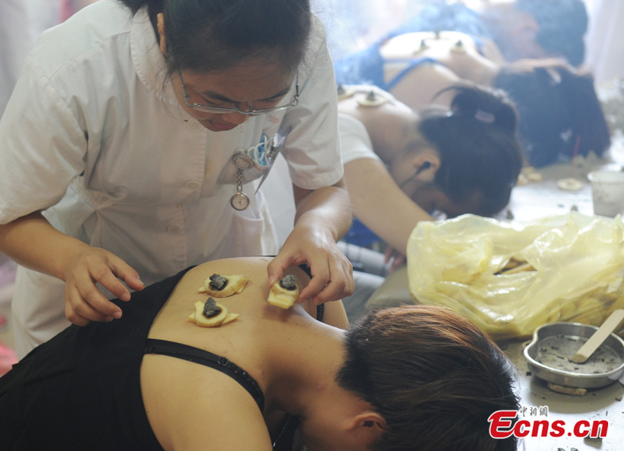 Citizens in Southeast China's Fujian province crowd into a local hospital to prevent or reduce the severity of winter ailments on July 23, 2013, during the three hottest periods, or dog days of summer. Treating winter diseases in summer is an ancient tradition in China. (CNS/ Liu Kegang)