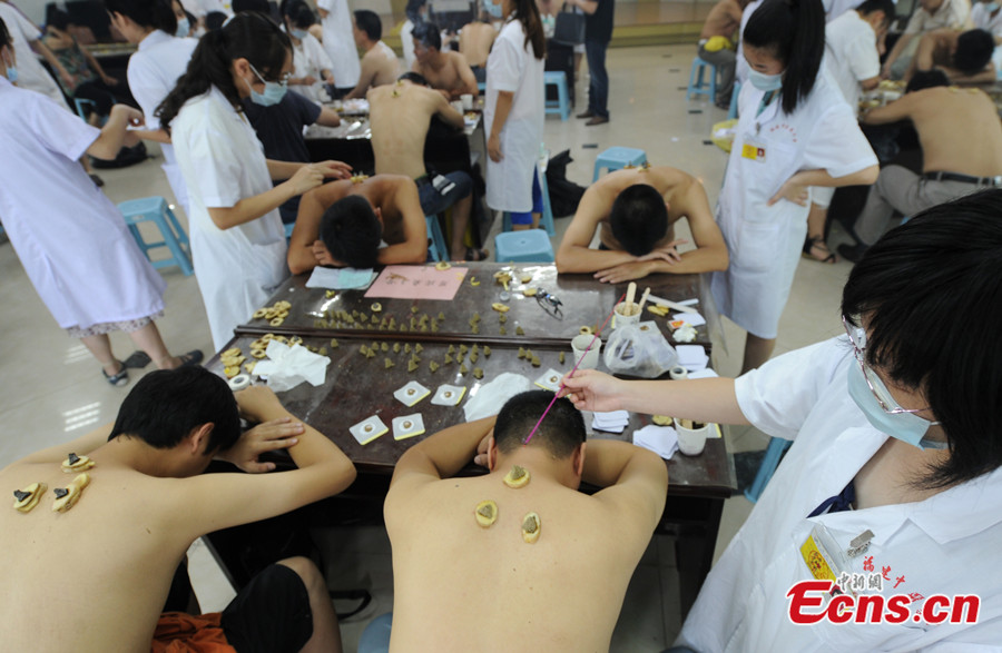 Citizens in Southeast China's Fujian province crowd into a local hospital to prevent or reduce the severity of winter ailments on July 23, 2013, during the three hottest periods, or dog days of summer. Treating winter diseases in summer is an ancient tradition in China. (CNS/ Liu Kegang)