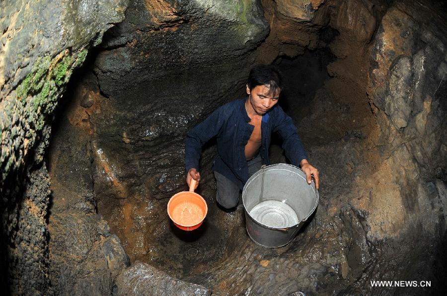 A villager fetches water in a karst cave at drought-hit Haoyou Village of Shanjiang Town of Fenghuang County, central China's Hunan Province, July 23, 2013. A drought that has lasted since early July has left 384,000 people short of drinking water in the province. Eighty-seven counties of 12 cities and prefectures in the province have been affected by the drought, with about 260,000 hectares of crops damaged and 216,000 heads of livestock short of water. Also in the province, 128 rivers and 124 reservoirs are dry. (Xinhua/Long Hongtao)