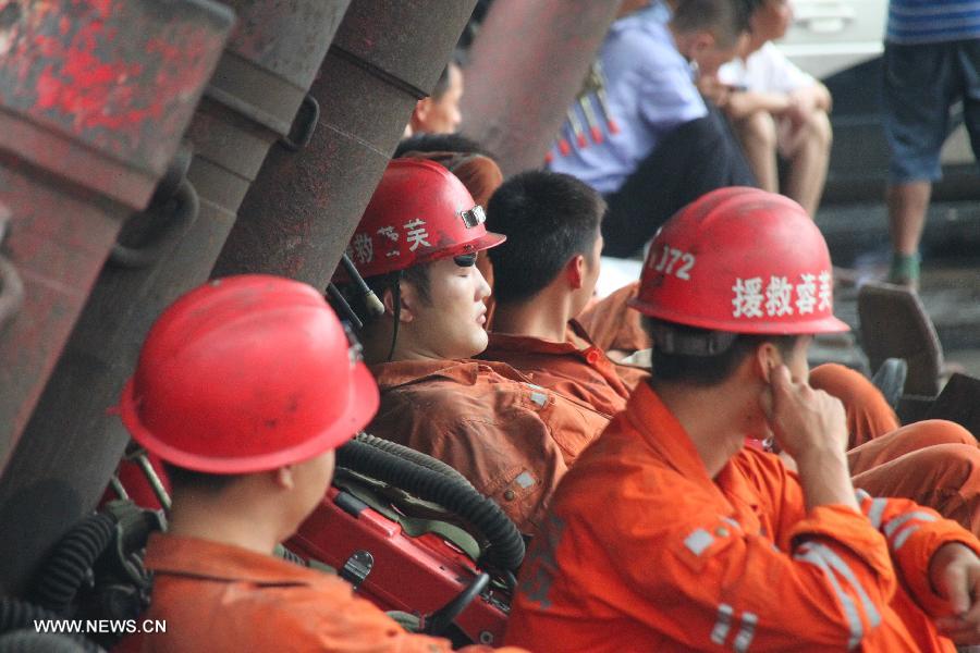 Rescuers rest outside the accident site at the Shanmushu Coal Mine, which is owned by the Sichuan Coal Group Furong Company, in Gongxian County of Yibin City, southwest China's Sichuan Province, July 23, 2013. Seven people remained trapped while 266 others have successfully escaped after the coal mine accident early on Tuesday morning. The seven trapped miners are all members of a team that was draining gas from the shaft. (Xinhua/Yi Youbo)