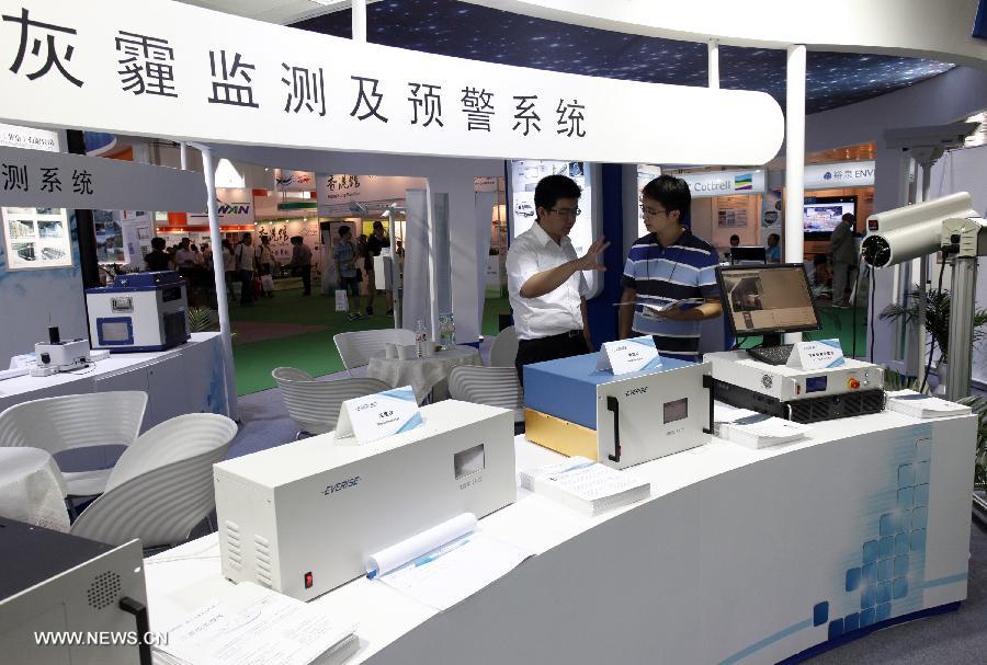 An exhibitor introduces to a visitor haze monitoring and warning system at the 13th China International Environment Protection Exhibition & Conference in Beijing, capital of China, July 23, 2013. The four-day exhibition kicked off on Tuesday, attracting around 500 enterprises from more than 20 countries and regions. (Xinhua/Yang Le)