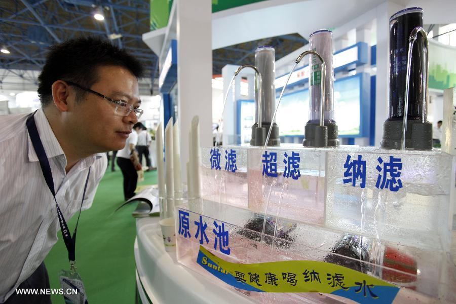 A visitor views drinking water purification and treatment equipment at the 13th China International Environment Protection Exhibition & Conference in Beijing, capital of China, July 23, 2013. The four-day exhibition kicked off on Tuesday, attracting around 500 enterprises from more than 20 countries and regions. (Xinhua/Yang Le)