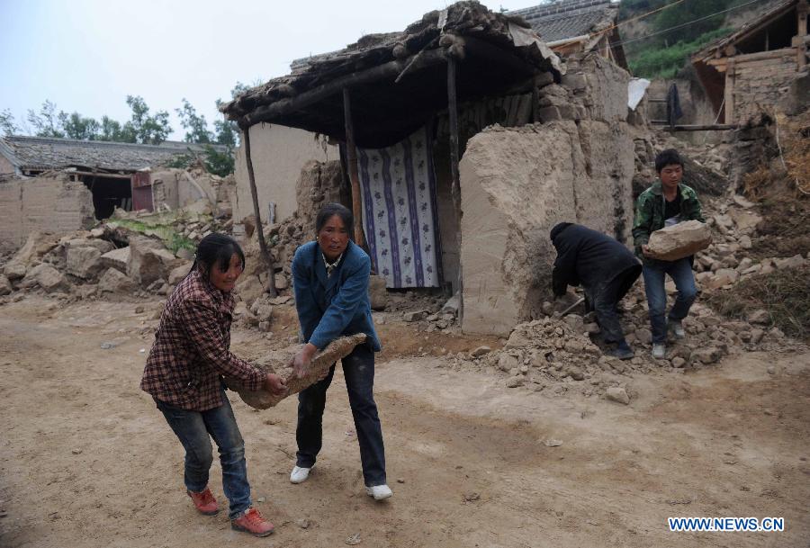Villagers clear debris at quake-hit Yongguang Village of Minxian County, northwest China's Gansu Province, July 23, 2013. The death toll has climbed to 94 in the 6.6-magnitude earthquake which jolted a juncture region of Minxian County and Zhangxian County in Dingxi City Monday morning. (Xinhua/Luo Xiaoguang)