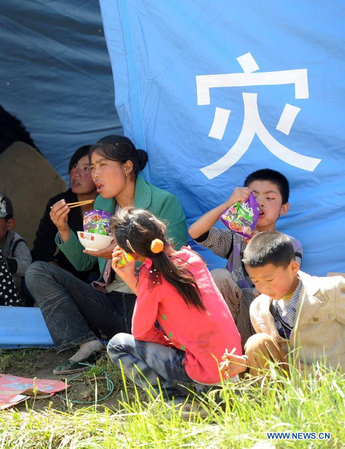 Villagers have lunch at a temporary settlement at quake-hit Yongguang Village of Minxian County, northwest China's Gansu Province, July 23, 2013. The death toll has climbed to 94 in the 6.6-magnitude earthquake which jolted a juncture region of Minxian County and Zhangxian County in Dingxi City Monday morning. (Xinhua/Luo Xiaoguang)