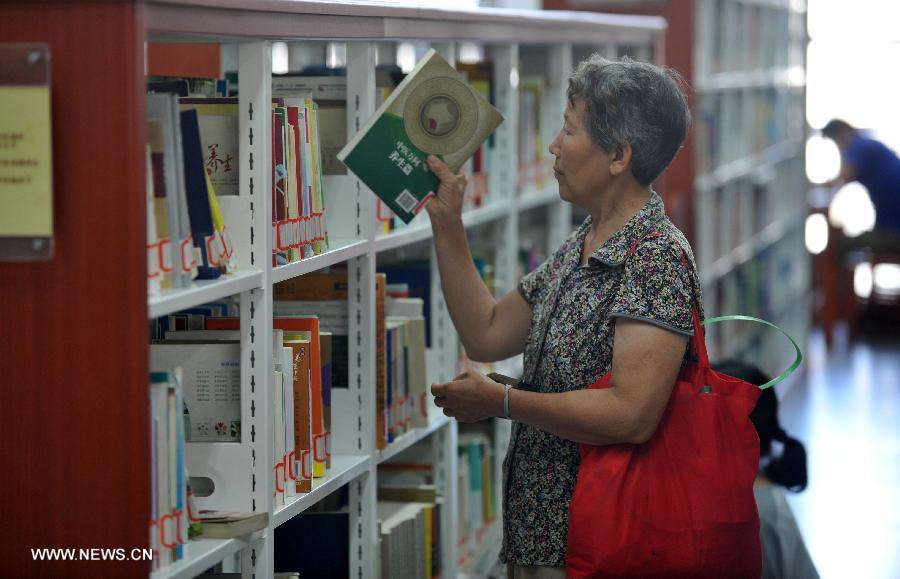 A citizen selects books at the Hebei Provincial Library in Shijiazhuang, capital of north China's Hebei Province, July 23, 2013. Many citizens enjoy reading at libraries in hot summer days. (Xinhua/Zhu Xudong)