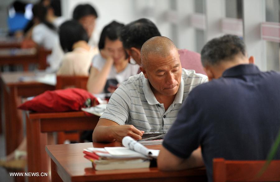 Citizens read books at the Hebei Provincial Library in Shijiazhuang, capital of north China's Hebei Province, July 23, 2013. Many citizens enjoy reading at libraries in hot summer days. (Xinhua/Zhu Xudong)