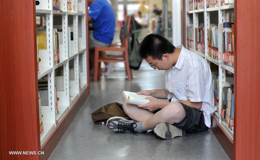 A citizen reads books at the Hebei Provincial Library in Shijiazhuang, capital of north China's Hebei Province, July 23, 2013. Many citizens enjoy reading at libraries in hot summer days. (Xinhua/Zhu Xudong)