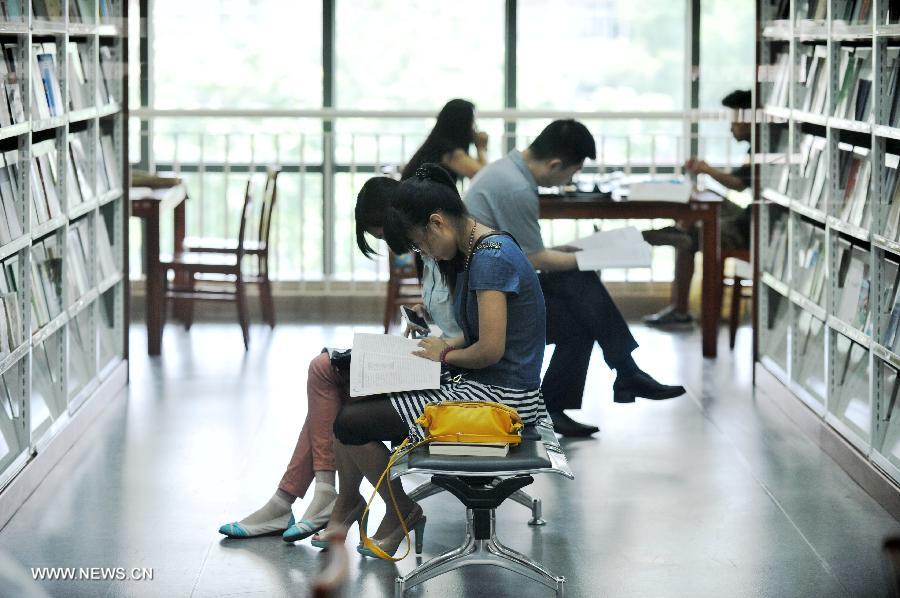 Citizens read books at the Hebei Provincial Library in Shijiazhuang, capital of north China's Hebei Province, July 23, 2013. Many citizens enjoy reading at libraries in hot summer days. (Xinhua/Zhu Xudong)