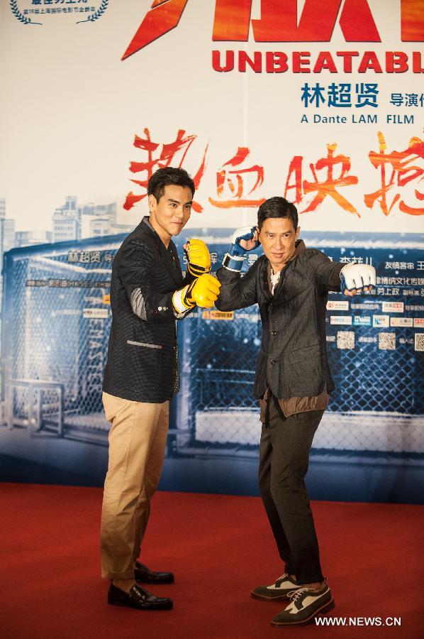 Actor Nick Cheung (R) and actor Eddie Peng pose for photos during the press conference of the movie "Unbeatable" in Beijing, capital of China, July 23, 2013. The movie "Unbeatable" which won both the Golden Goblet for best actor and actress in the 16th Shanghai International Film Festival will hit the screen on Aug. 16. (Xinhua/Li Yan)