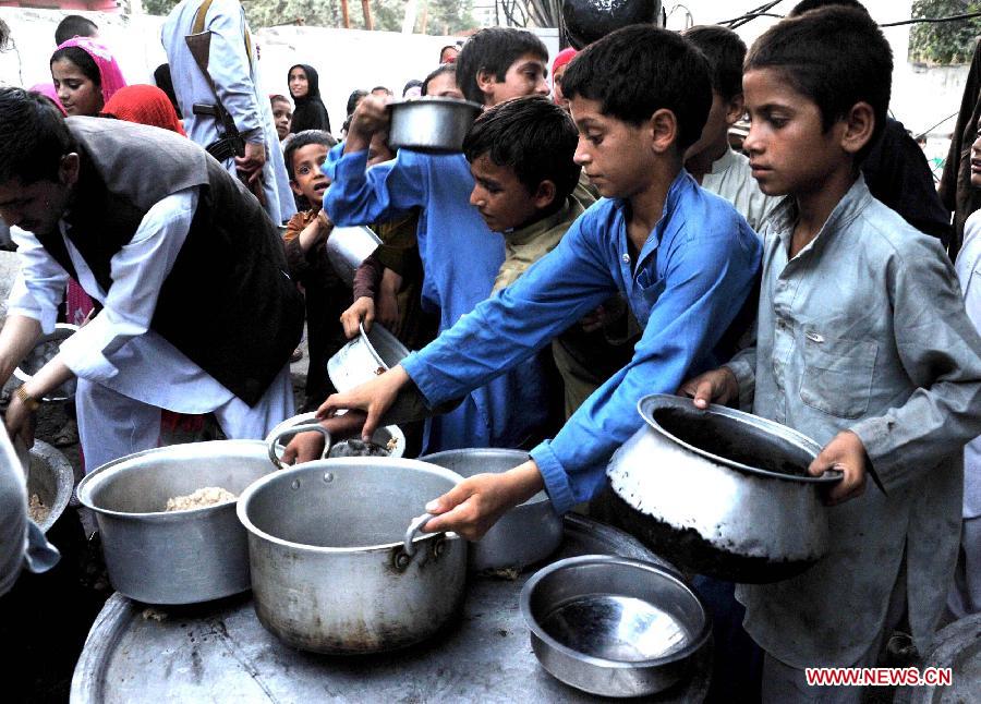 Afghan children receive food donated by rich people during holy month of Ramadan in Nangarhar province in eastern Afghanistan on July 23, 2013. (Xinhua/Tahir Saf)