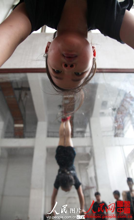 Children do handstands in front of a mirror. (vip.people.com.cn/Liang Hongyuan)