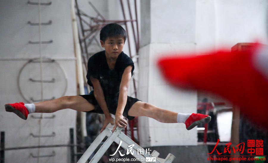 A child in the acrobatic troupe do daily trainings. (vip.people.com.cn/Liang Hongyuan)
