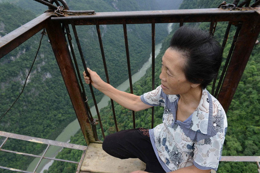 A woman uses a ropeway to go over across a valley on July 23, 2013 in Central China's Hubei province. (Photo/Xinhua)