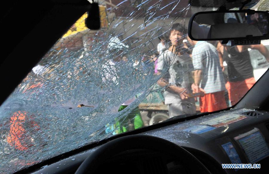 A vehicle's windshield is broken in an explosion at a cake shop on Guangming Road in Beijing, capital of China, July 24, 2013. A gas blast ripped through the cake shop Wednesday morning, leaving a number of people injured and vehicles damaged. (Xinhua/Li Wen)
