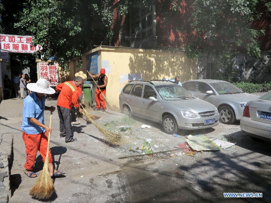 Sanitation workers clean the explosion site at a cake shop on Guangming Road in Beijing, capital of China, July 24, 2013. A gas blast ripped through the cake shop Wednesday morning, leaving a number of people injured and vehicles damaged. (Xinhua/Wang Zhen)