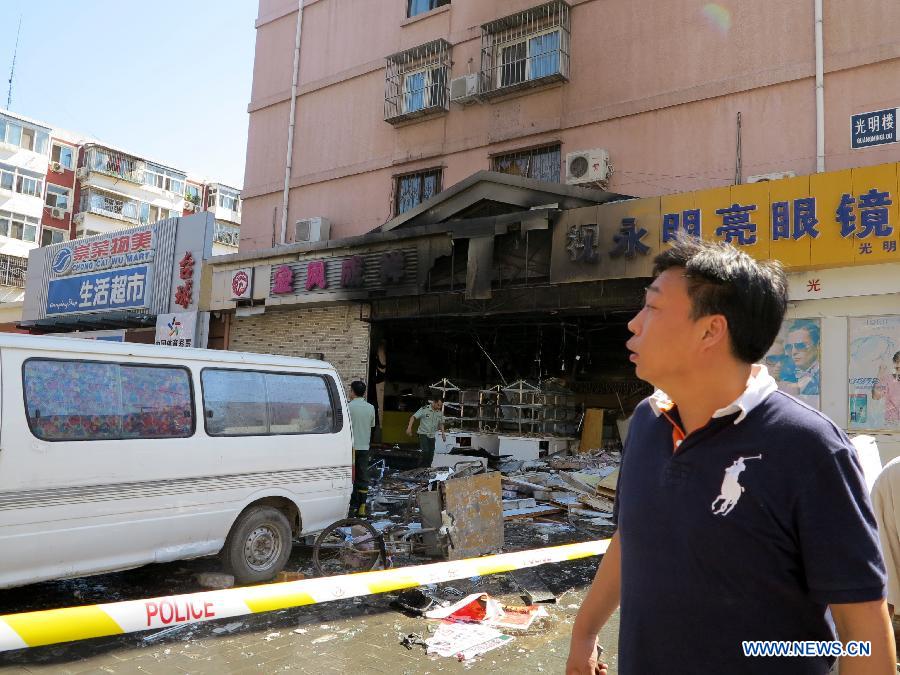 Firemen work at the explosion site of a cake shop on Guangming Road in Beijing, capital of China, July 24, 2013. A gas blast ripped through the cake shop Wednesday morning, leaving a number of people injured and vehicles damaged. (Xinhua/Wang Zhen)