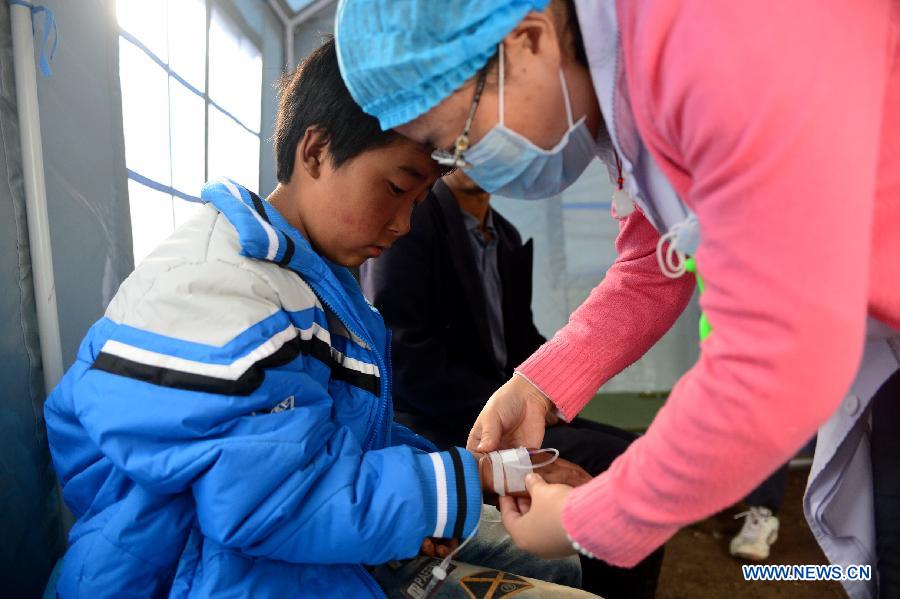 A child receives intravenous infusion at a tent in quake-hit Yongxing Village of Minxian County, northwest China's Gansu Province, July 24, 2013. The death toll has climbed to 95 in the 6.6-magnitude earthquake which jolted a juncture region of Minxian County and Zhangxian County in Dingxi City Monday morning. (Xinhua/Zhang Meng)