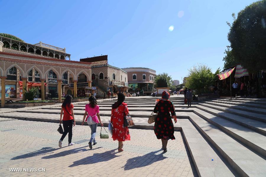 Women walk in the Id Kah Square in Kashgar, northwest China's Xinjiang Uygur Autonomous Region, July 16, 2013.(Xinhua/Wen Juan)