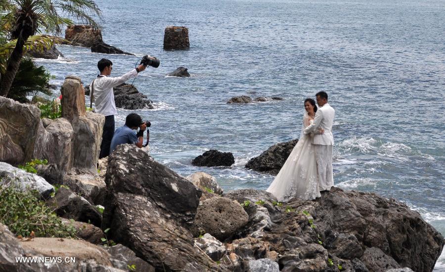 A couple pose for wedding photos on the beach in Sanya, south China's Hainan Province, July 24, 2013. (Xinhua/Wang Junfeng)
