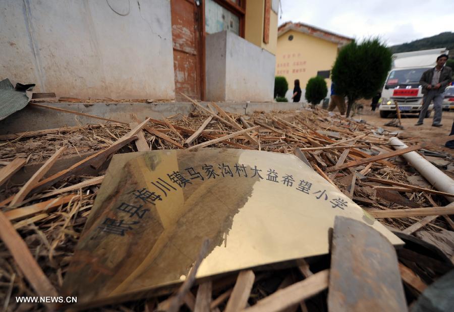 A doorplate bearing the school name lies on ruins at a primary school in the quake-hit Majiagou Village in Meichuan Township, Minxian County, northwest China's Gansu Province, July 24, 2013. Over 360 schools in Gansu's Minxian and Zhangxian counties were destroyed by the 6.6-magnitude quake that occurred on Monday, affecting 77,000 students, according to the local authorities. (Xinhua/Luo Xiaoguang)