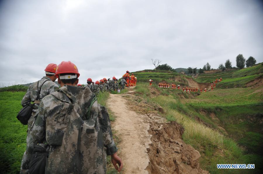 Rescuers carrying relief supplies head for Zhongzhai Town of quake-stricken Minxian County, northwest China's Gansu Province, July 24, 2013. Around 150 soldiers from an engineer regiment of the Lanzhou Military Area Command have entered the quake-hit Zhongzhai Town, bringing relief materials to locals, after a 6.6-magnitude quake hit northwest China's Gansu Province on Monday morning. (Xinhua/Cao Baiming) 