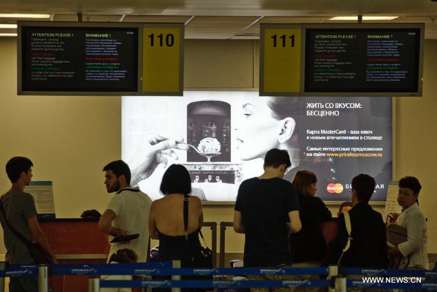 Passengers check in at terminal E of the Sheremetyevo airport in Moscow, Russia, July 24, 2013. A Russian lawyer who has been working on Snowden's behalf has arrived at Moscow's Sheremtyevo Airport, heightening speculations that the U.S. whistleblower may have been granted permission to leave the transit area and enter Russia. (Xinhua/Jiang Kehong)