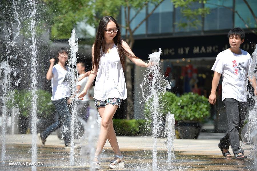 A young woman cools off in a fountain in Beijing, capital of China, July 24, 2013. A heat wave hit Beijing on Wednesday, with the highest temperature reaching 36 degrees Celsius. (Xinhua/Li Xin) 