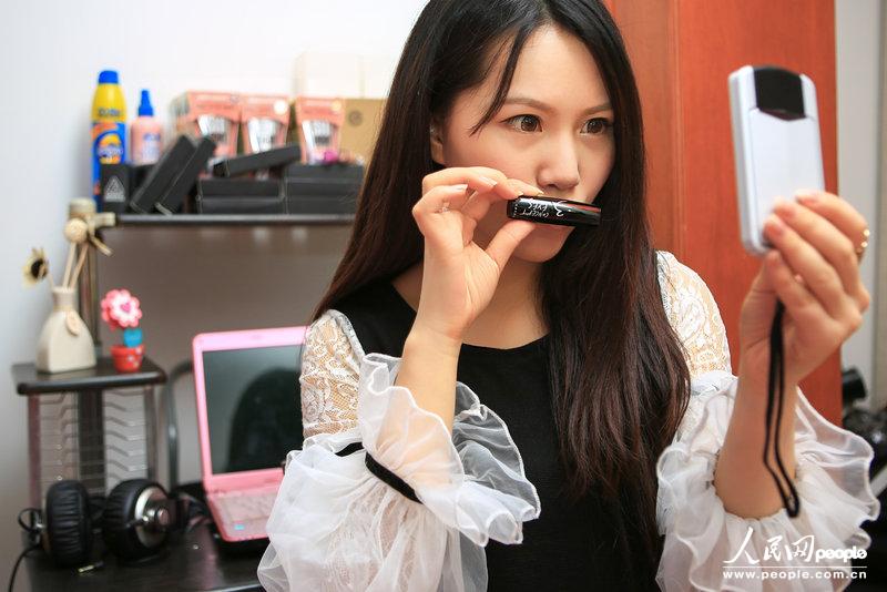 Zhang Yakai takes photo for a lipstick. Zhang tried every product before selling it online. (Photo/CFP)
