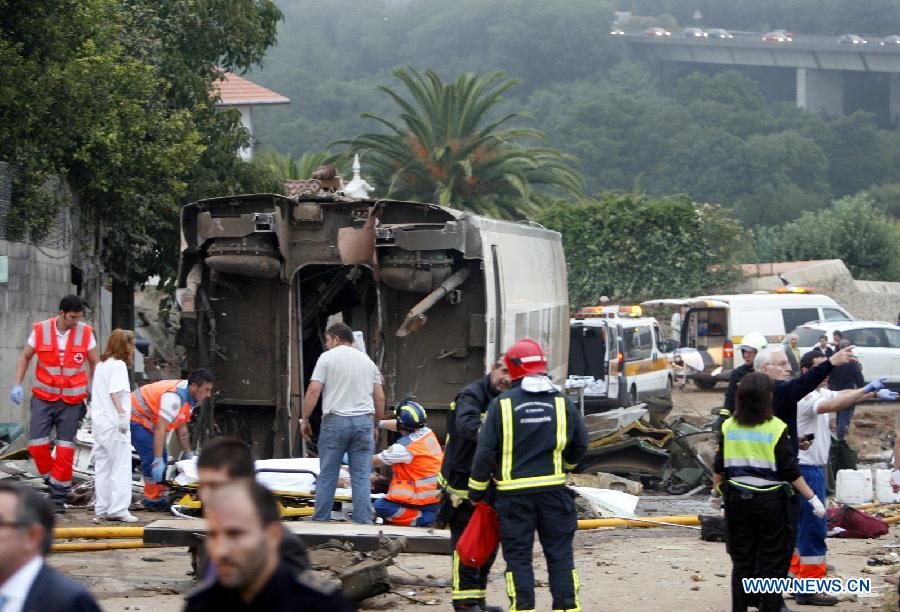 Rescuers work at the site where a train crashed, at the entrance of Santiago de Compostela Station, in the autonomous community of Galicia, northwest of Spain, on July 24, 2013. Up to 35 people have died and around 100 injured after a train derailed just outside the city of Santiago de Compostela in the region of Galicia in north-western Spain on Wednesday evening.(Xinhua/Oscar Corral)