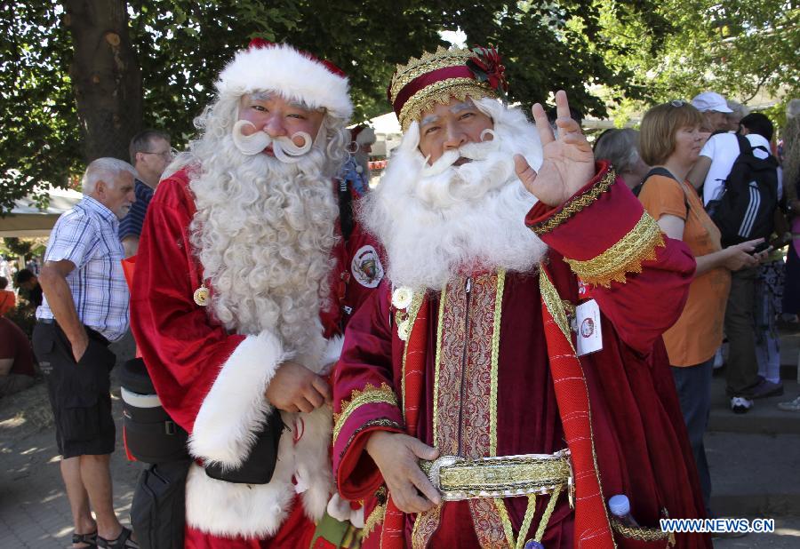 Santa Johnny (L), from China's Hong Kong, poses with his colleague after he won the "World Best Santa Claus" in the annual World Santa Claus Congress in Copenhagen, Denmark, July 24, 2013. (Xinhua/Yang Jingzhong)