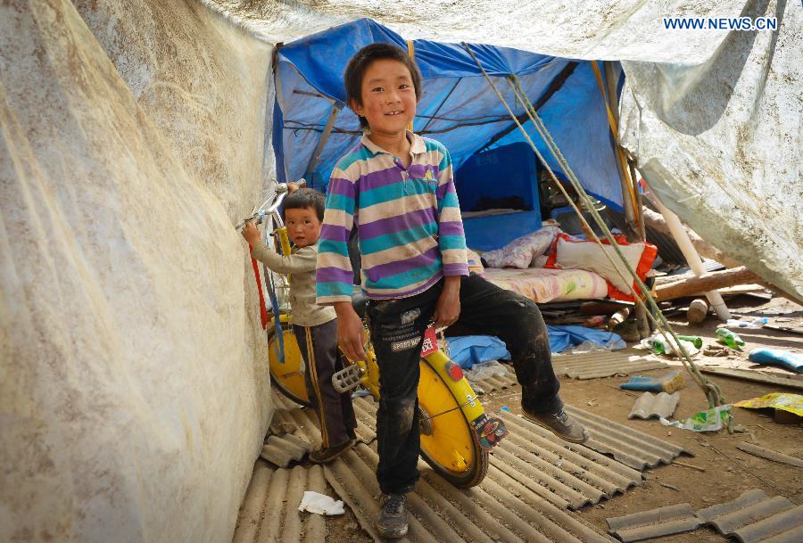 Children play at a makeshift settlement in Meichuan Town of quake-hit Minxian County, northwest China's Gansu Province, July 24, 2013. A 6.6-magnitude quake hit northwest China's Gansu Province on Monday morning, leaving 95 dead and 1,001 injured. (Xinhua/Liu Xiao) 