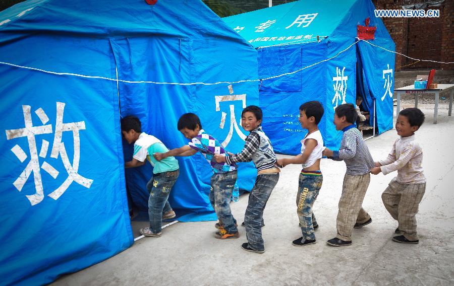 Children play at a makeshift settlement in Shendu Township of quake-hit Minxian County, northwest China's Gansu Province, July 24, 2013. A 6.6-magnitude quake hit northwest China's Gansu Province on Monday morning, leaving 95 dead and 1,001 injured. (Xinhua/Liu Xiao) 